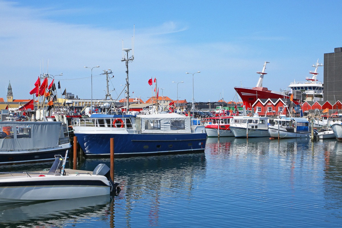 Fischkutter vor den roten Hallen im Hafen von Skagen